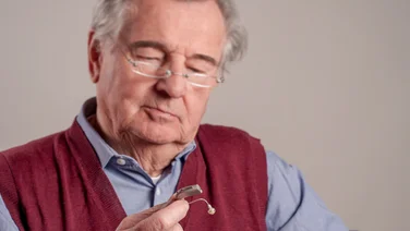man taking out rechargeable hearing aid